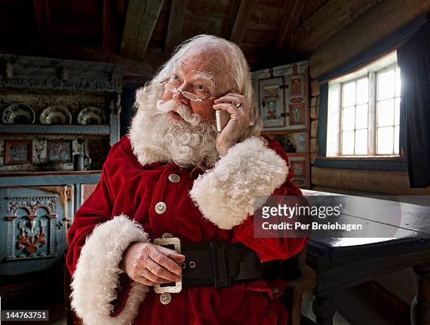 santa claus using his smart phone - kerstman stockfoto's en -beelden