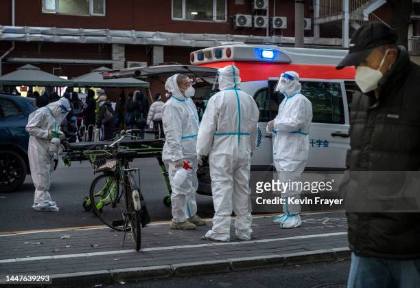 Ambulance drivers wear PPE as they wait outside after dropping a patient off at a fever clinic at a local hospital on December 8, 2022 in Beijing,...