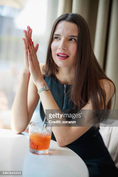 beautiful woman having cocktail at restaurant table and negotiating business in meeting - bar drink establishment stock pictures, royalty-free photos & images