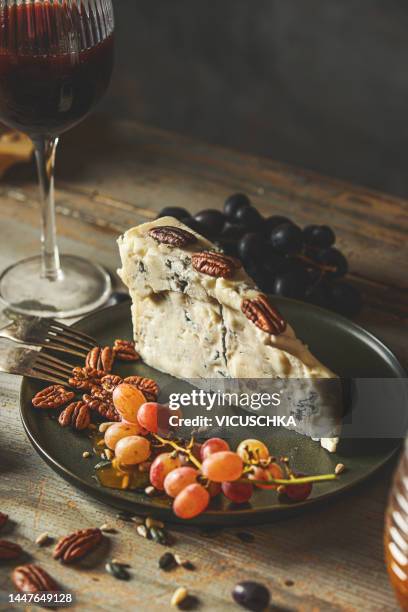 piece of gorgonzola cheese with nuts, grapes and red wine - roquefort cheese stock pictures, royalty-free photos & images