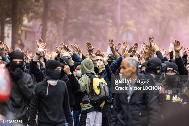 Manifestants black bloc bras en l'air lors de la manifestation demandant des hausses de salaires le 18 octobre 2022 à Paris.