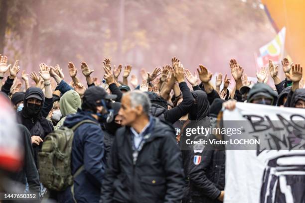 Manifestants black bloc bras en l'air lors de la manifestation demandant des hausses de salaires le 18 octobre 2022 à Paris.