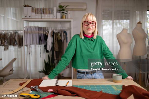 diseñadora sonriente en un estudio de ropa. - fashion designer fotografías e imágenes de stock