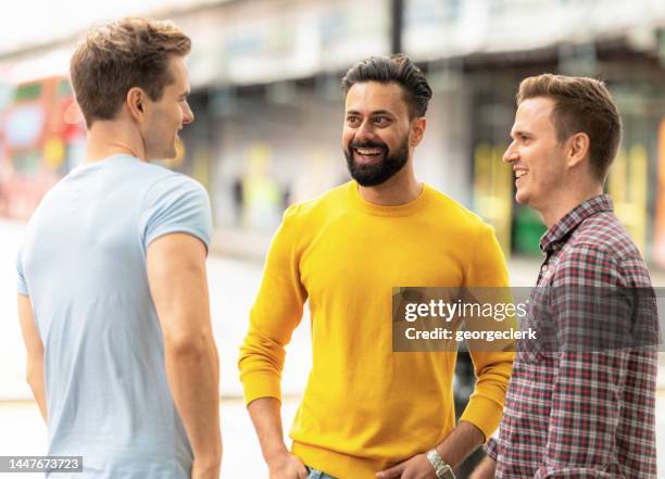 three men chatting on the street - indian man 30s beard stock pictures, royalty-free photos & images