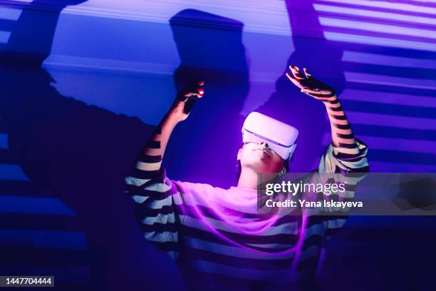 modern african american woman is using vr glasses to access metaverse world - media availability stock-fotos und bilder