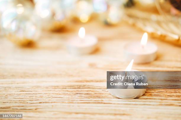 burning tealight candles against sparkling new year background. - tealight stock pictures, royalty-free photos & images