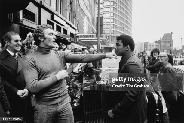 Heavyweight boxer Joe Bugner greets world heavyweight boxing champion, Muhammad Ali outside the Horseshoe pub in Tottenham Court Road, where Bugner's...