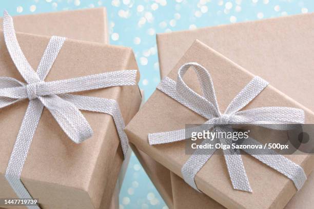 gift boxes on light blue sparkling background - gift lounge stock-fotos und bilder