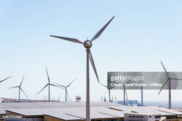 white turbines at wind farm with power station and sea in background,arid landscape on sunny day,tenerife,santa cruz de tenerife,spain - the catalyst santa cruz stock pictures, royalty-free photos & images