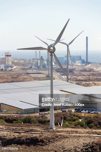 white turbines at wind farm with power station and sea in background,arid landscape on sunny day,tenerife,santa cruz de tenerife,spain - the catalyst santa cruz stock pictures, royalty-free photos & images
