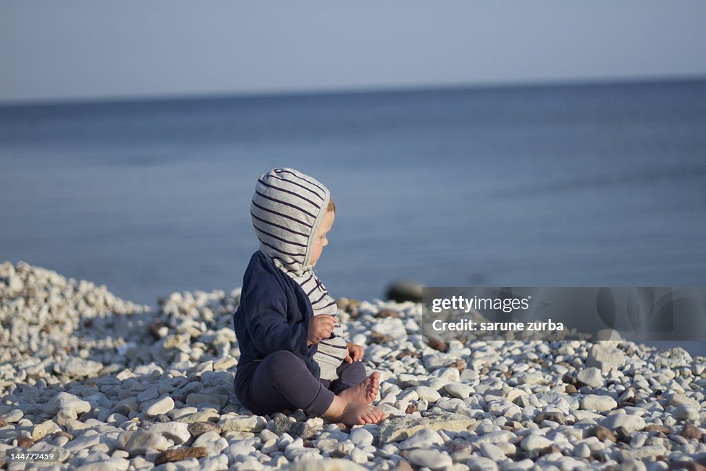 Small baby girl sitting on stones