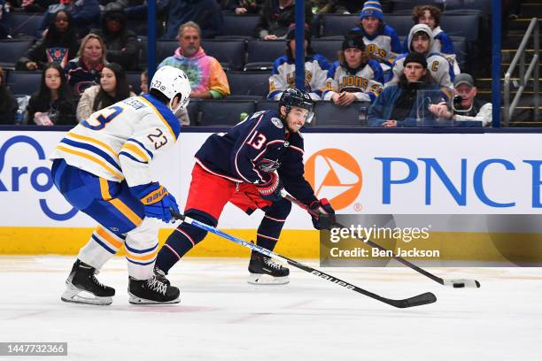 Johnny Gaudreau of the Columbus Blue Jackets skates with the puck as Mattias Samuelsson of the Buffalo Sabres defends during the third period of a...