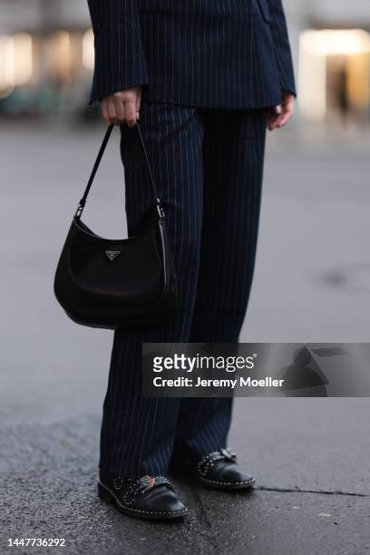 Model and Content Creator Marlies Pia Pfeifhofer wearing LeGer by Lena Gercke navy blue pinstriped suit, Givenchy black leather boots and black shiny...