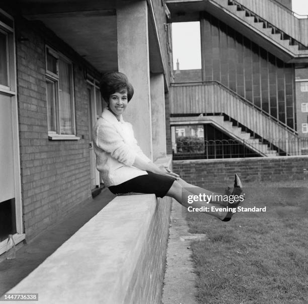 British singer Helen Shapiro sitting on a wall outside her home on the Parkside Estate in Victoria Park Road, Hackney, on May 18th, 1962.