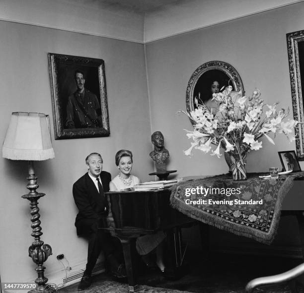 Newly-married John Wodehouse, 4th Earl of Kimberley , sitting at the piano with his fourth wife, the model Margaret Simons, on July 6th, 1961.