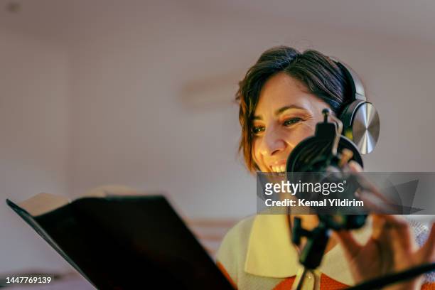 beautiful young woman recording podcast - story telling in the workplace stockfoto's en -beelden