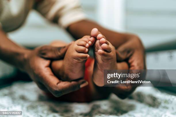 winzige neugeborene babys füße auf - heels hand stock-fotos und bilder