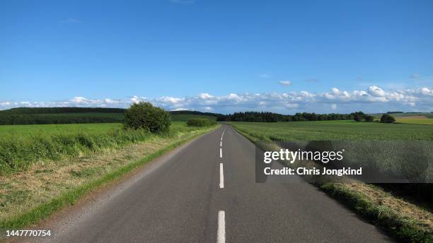 two lane road curving through rural countryside - two lane highway stock-fotos und bilder