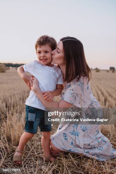 mother and son kiss at sunset in the field - couple portrait soft stock pictures, royalty-free photos & images