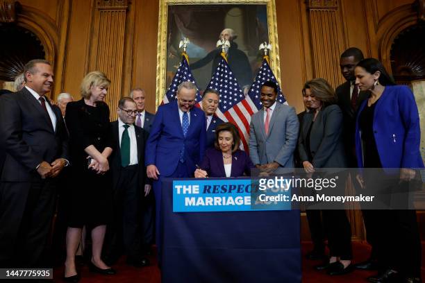 House Speaker Nancy Pelosi participates in a bill enrollment ceremony alongside Senate Majority Leader Chuck Schumer and a bipartisan group of...