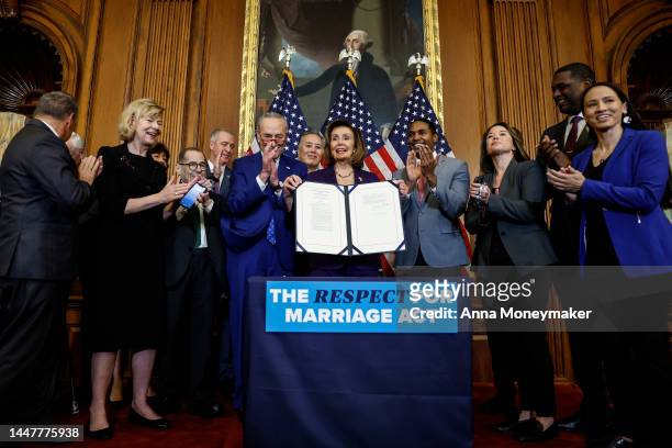 House Speaker Nancy Pelosi participates in a bill enrollment ceremony alongside Senate Majority Leader Chuck Schumer and a bipartisan group of...
