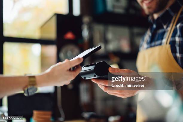 anonymous person paying with their cell phone - kassa bildbanksfoton och bilder