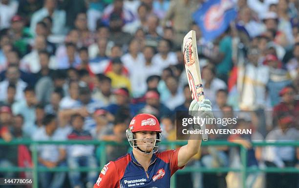 Delhi Daredevils player David Warner waves his bat after scoring a half century in 25 balls during the IPL Twenty20 cricket match between Kings XI...