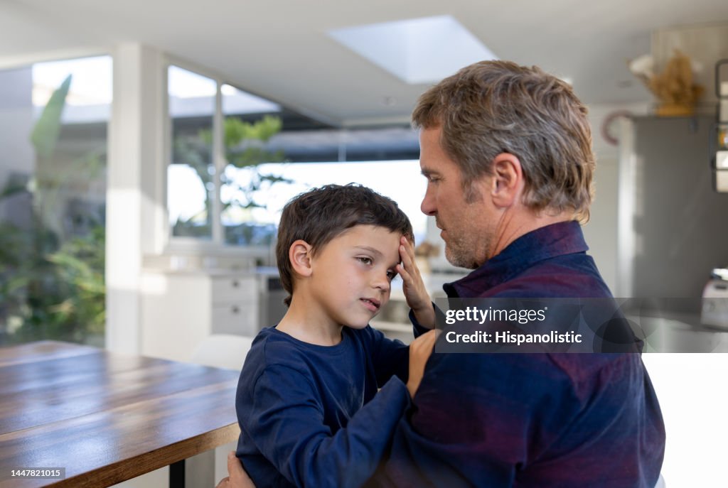 Father comforting his son after he bump his head