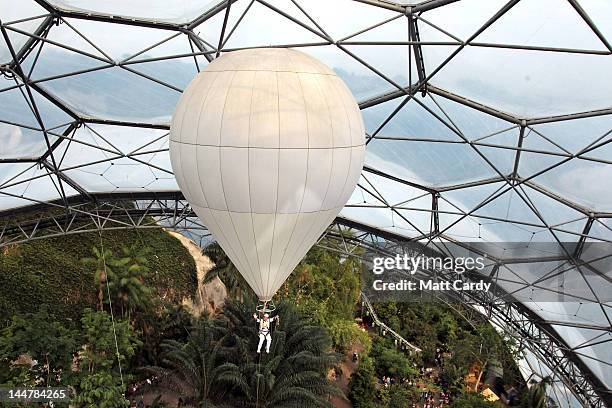 Television presenter, adventurer and writer Ben Fogle waves as he takes the Olympic flame in a lantern above the tree canopy in a hot air balloon...