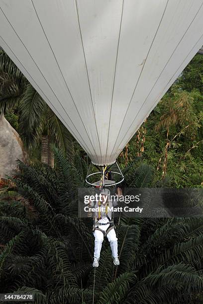 Television presenter, adventurer and writer Ben Fogle waves as he takes the Olympic flame in a lantern above the tree canopy in a hot air balloon...