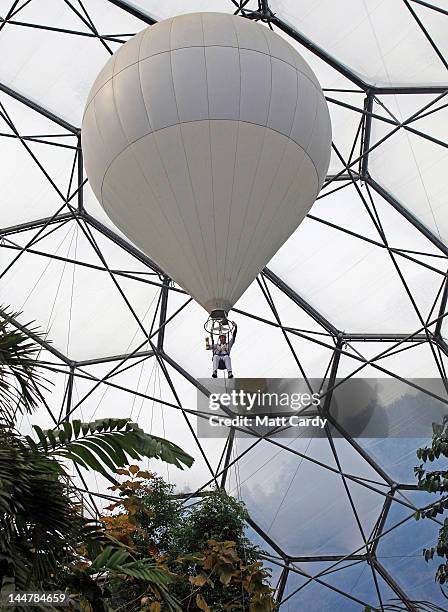 Television presenter, adventurer and writer Ben Fogle waves as he takes the Olympic flame in a lantern above the tree canopy in a hot air balloon...