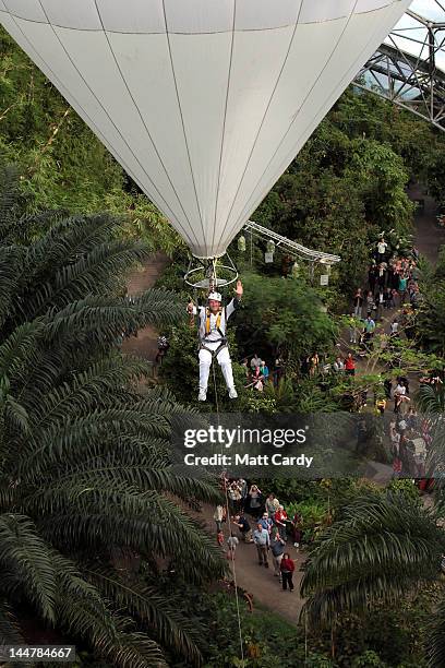 Television presenter, adventurer and writer Ben Fogle waves as he takes the Olympic flame in a lantern above the tree canopy in a helium balloon...