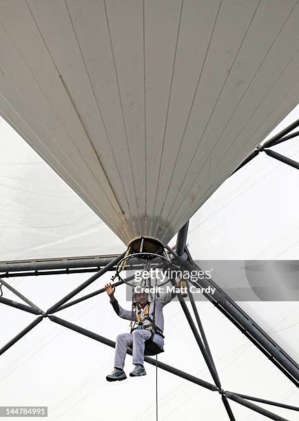 Television presenter, adventurer and writer Ben Fogle waves as he takes the Olympic flame in a lantern above the tree canopy in a helium balloon...