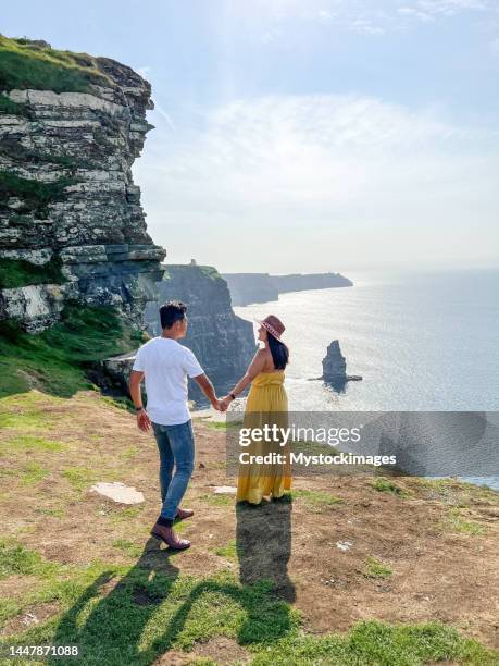 diverse couple traveling in ireland and exploring the coastline - ireland coastline stock pictures, royalty-free photos & images