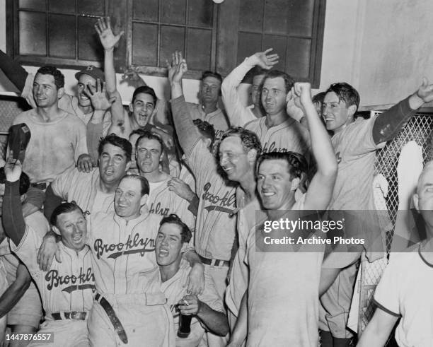 Brooklyn Dodgers baseball players celebrate their pennant clinch after defeating the Boston Braves, in their dressing room at Braves Field in Boston,...