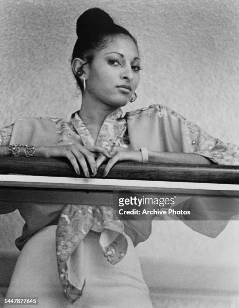 American actress and singer Pam Grier leaning on the handrail of a glass balustrade, United States, circa 1975.