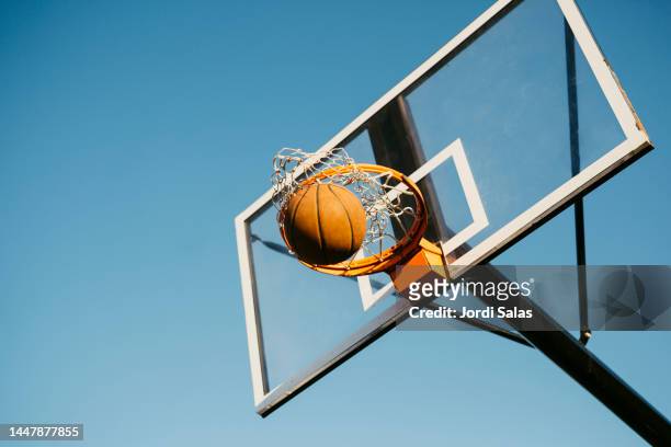basketball ball getting in to the basket - basketball hoop imagens e fotografias de stock