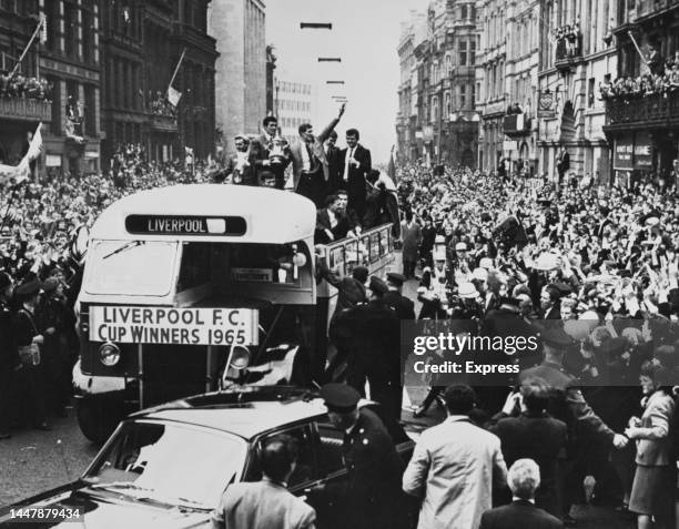 Cup-winners Liverpool FC in an open-top bus are greeted by crowds of fans as the team parade the trophy through the streets of Liverpool, Merseyside,...