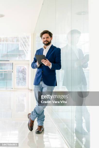 full length view of handsome young businessman with beard using technology on white background indoors. - guy with phone full image ストックフォトと画像