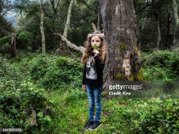 girl standing in a forest holding a plant, italy - 13 years old girl in jeans stock pictures, royalty-free photos & images