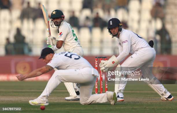 Babar Azam of Pakistan edges the ball past Ben Stokes of England and Ollie Pope of England during day one of the First Test Match between Pakistan...