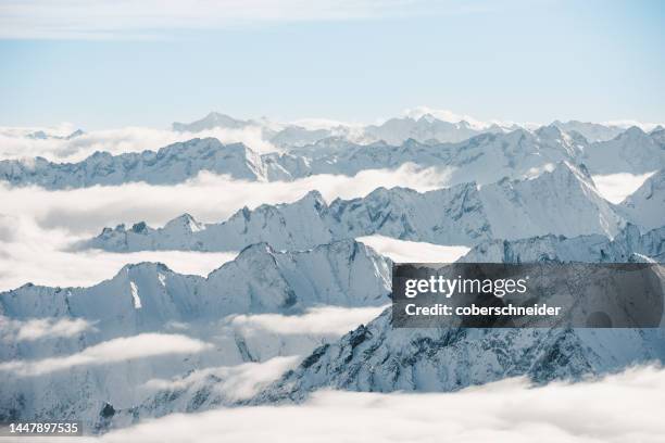 aerial view of snowcapped mountain peaks through clouds, hintertux glacier, tyrol, austria - tirol deelstaat stockfoto's en -beelden