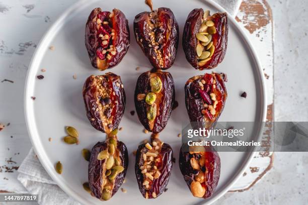 overhead view of medjool dates stuffed with nut butter, dark chocolate, assorted nuts and seeds - stuffing food bildbanksfoton och bilder