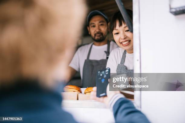 customer making a mobile payment at food truck - mobile payment stock pictures, royalty-free photos & images