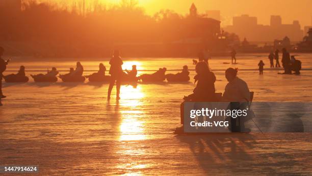 People skate on the frozen Songhua River at sunset on December 8, 2022 in Harbin, Heilongjiang Province of China.