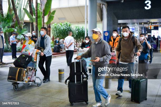 Travellers walk out of a terminal building at Haikou Meilan International Airport as Haikou no longer requires people who return to this city to show...