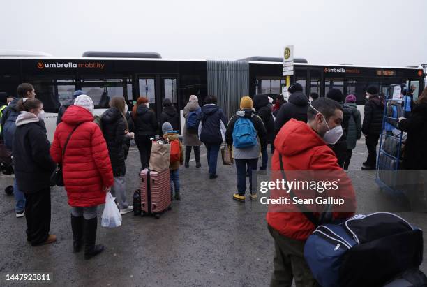 Refugees from Ukraine board a bus to the city center at the refugees registration center at former Tegel airport on December 09, 2022 in Berlin,...