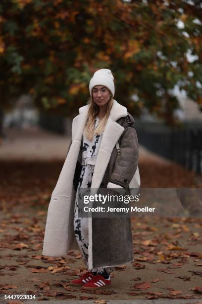 Sonia Lyson is seen wearing Adidas red Gazelle sneaker, Twenty Fall brown long shearling coat, Gucci Attache beige bag, Gobi Cashmere beige hat, Zara...