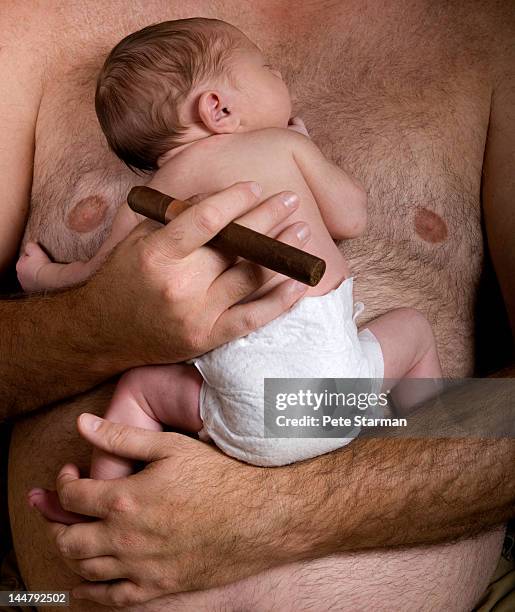 father with a cigar in hand holding a baby - female hairy chest photos et images de collection