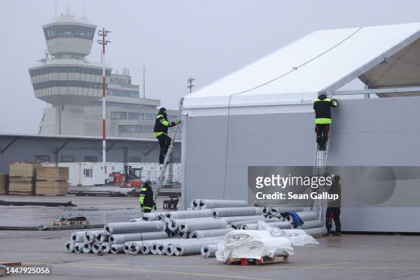 Workers construct one of at least half a dozen new temporary accommodations halls at the registration center for Ukrainian refugees at former Tegel...